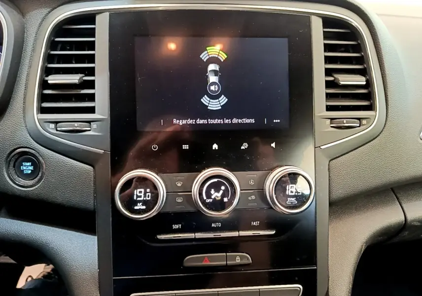 Vue rapprochée du tableau de bord noir de la Renault Mégane Business E-Tech hybride, avec écran tactile et commandes climatisation digitales.
