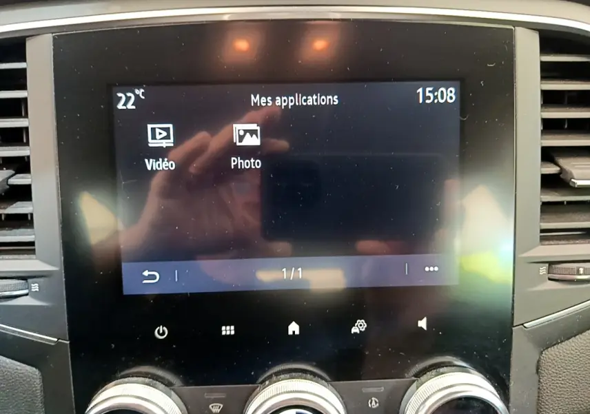 Écran tactile central affichant les applications vidéo et photo dans l’habitacle d’une Renault Mégane blanche hybride rechargeable.
