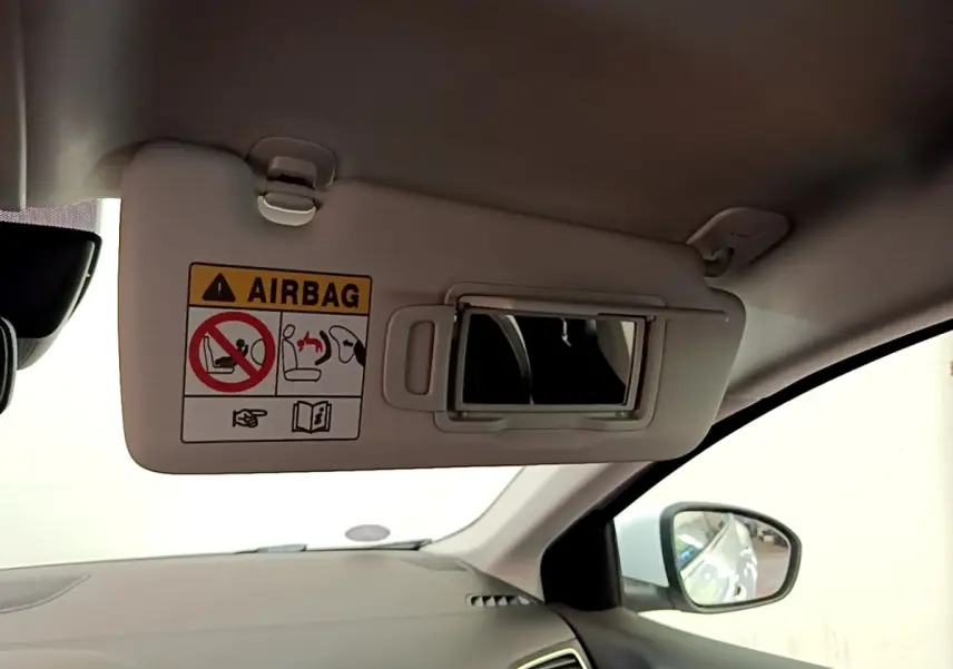 Vue intérieure côté passager de la Renault Mégane Business E-Tech hybride blanche, avec pare-soleil et miroir intégré.
