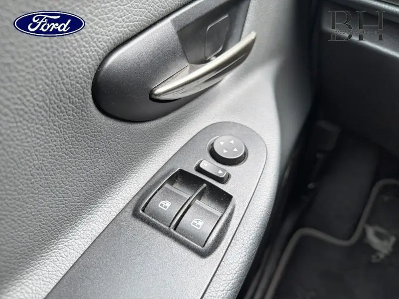 Gros plan sur la commande des vitres électriques côté conducteur d'une Lancia Ypsilon gris Argento, avec poignée de porte noire.