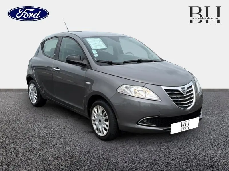 Vue 3/4 avant droit d'une Lancia Ypsilon 1.2 8v Gold Stop&Start gris Argento avec calandre chromée et phares halogènes.