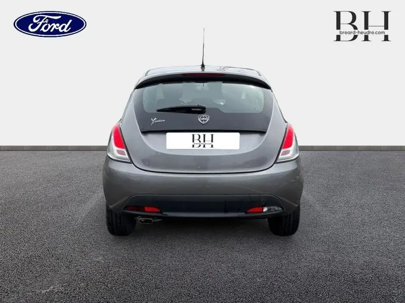 Vue arrière d'une Lancia Ypsilon gris Argento 2014 avec feux arrière allongés et sortie d'échappement chromée visible.