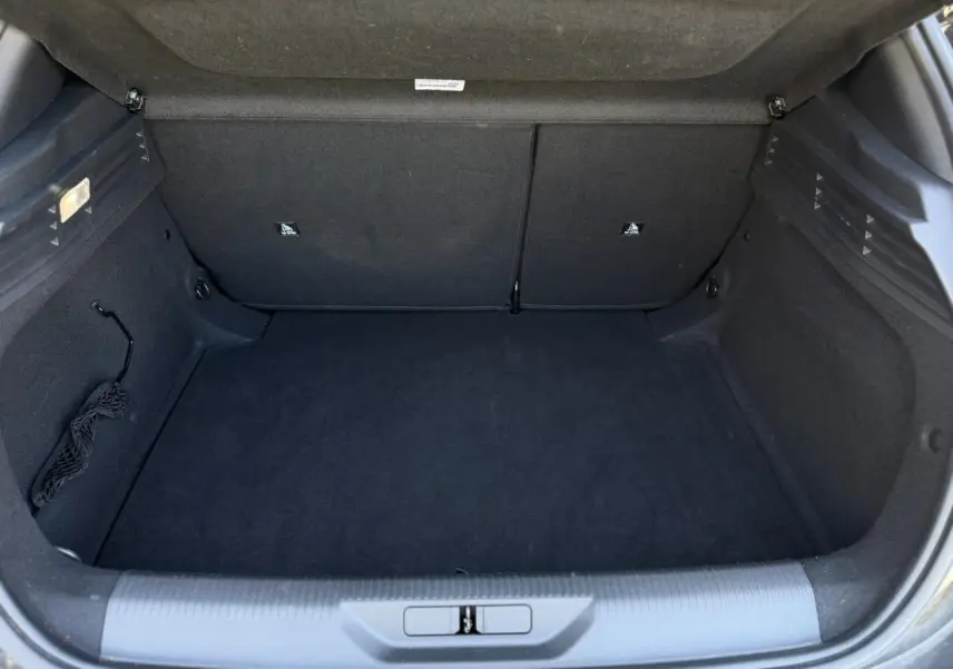 Coffre ouvert vu de face, intérieur noir avec revêtement tissu et filet de rangement latéral visible.