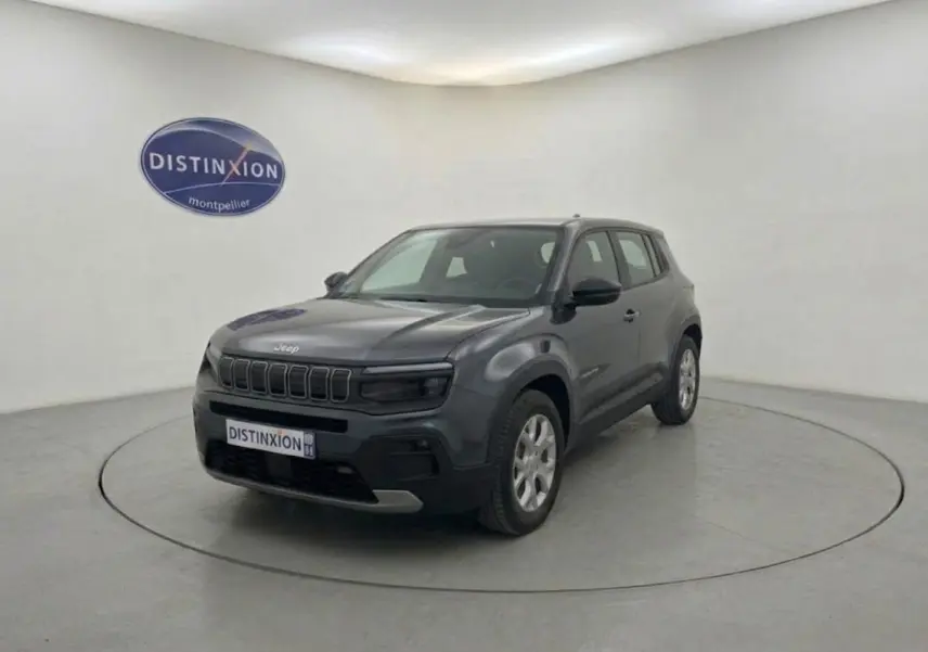 Jeep Avenger électrique gris en 3/4 avant droit, SUV compact avec calandre distinctive et jantes argentées.
