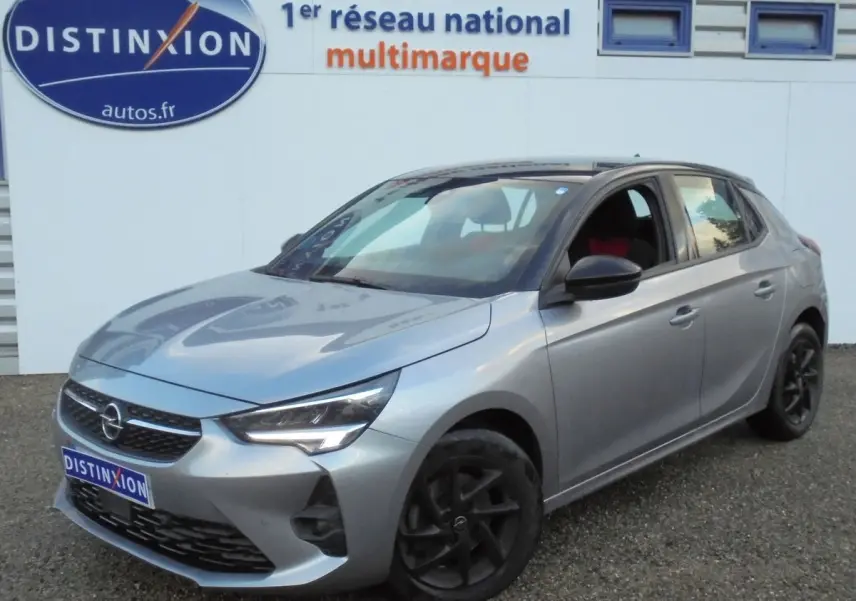 Opel Corsa gris quartz métal vue 3/4 avant droit, avec jantes noires et calandre distinctive.