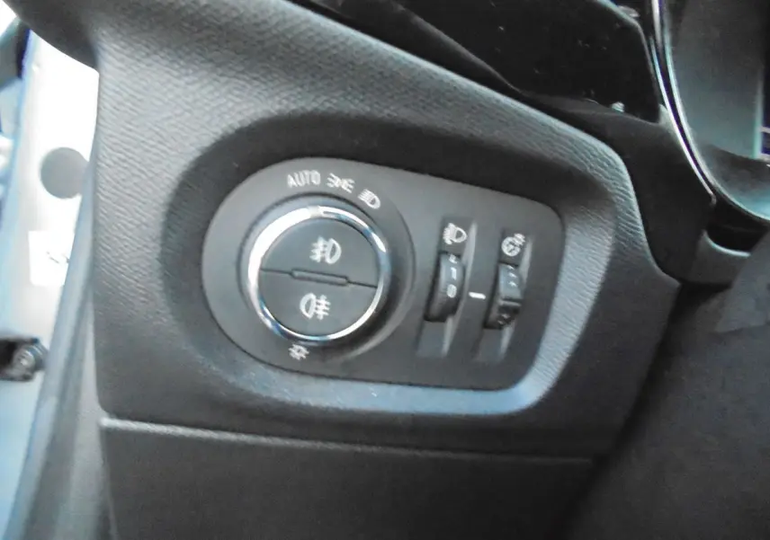Gros plan sur les commandes d'éclairage intérieures de l'Opel Corsa gris quartz, côté gauche du tableau de bord.