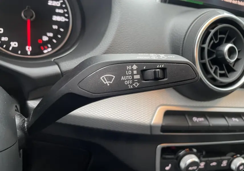 Gros plan sur la commande d’essuie-glace côté gauche du tableau de bord d’un Audi Q2 noir Mythic 2023.