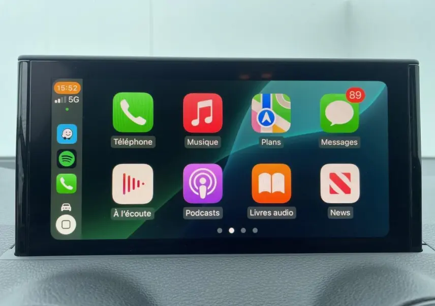 Écran multimédia tactile de l'Audi Q2 2023 affichant les applications Apple CarPlay en intérieur noir.