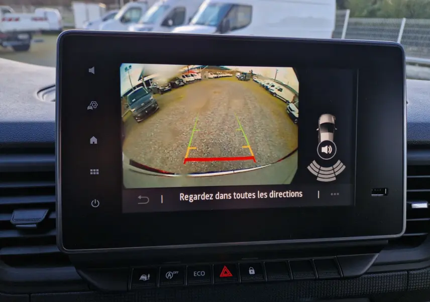Écran tactile intérieur montrant la caméra de recul du Renault Trafic Fourgon gris Highland, avec lignes d'aide au stationnement.
