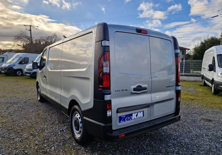 Vue 3/4 arrière droite du Renault Trafic Fourgon gris Highland, avec portes arrière fermées et feux arrière visibles.