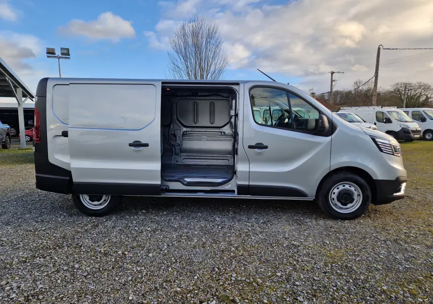 Vue latérale droite d'un Renault Trafic Fourgon gris Highland avec porte coulissante ouverte montrant l'espace de chargement vide.