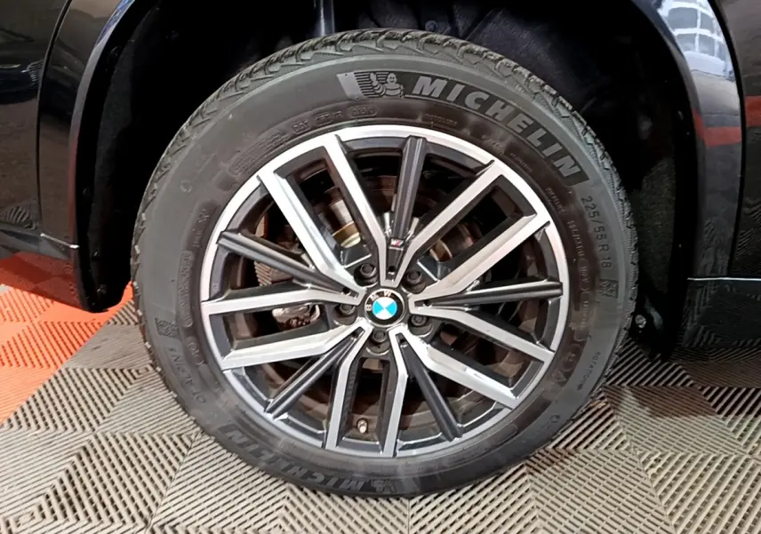 Gros plan sur la roue avant gauche noire du BMW X1 xDrive23i M Sport avec jante alliage et pneu Michelin
