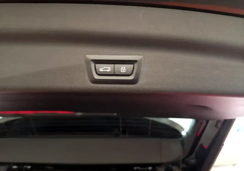 Gros plan sur les boutons d'ouverture et de verrouillage électrique du coffre du BMW X1 noir xDrive23i M Sport 2023.