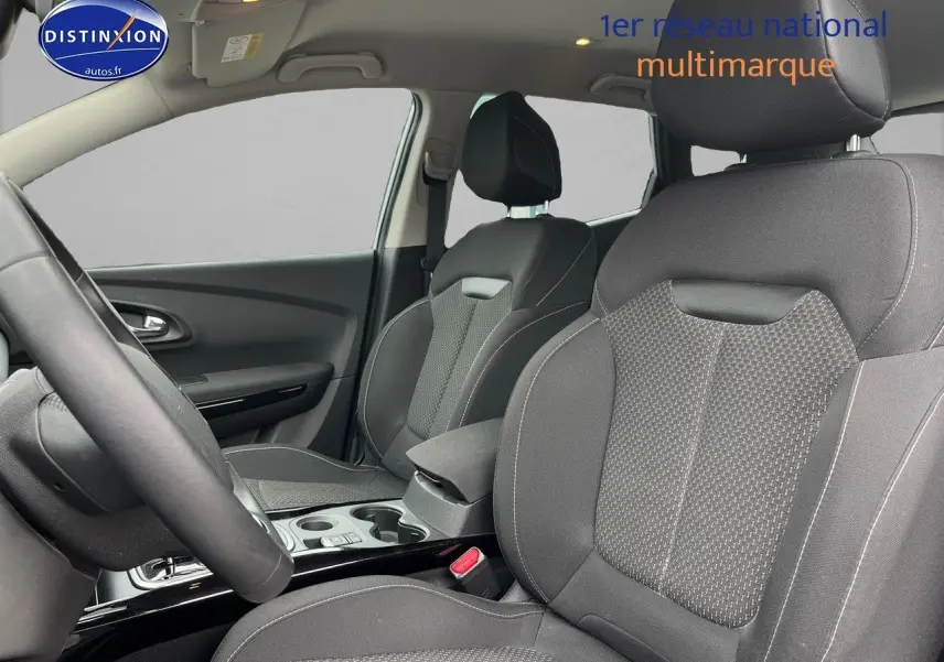 Vue intérieure côté conducteur du Renault Kadjar 2018, sièges tissu carbone foncé avec accoudoir central et console.