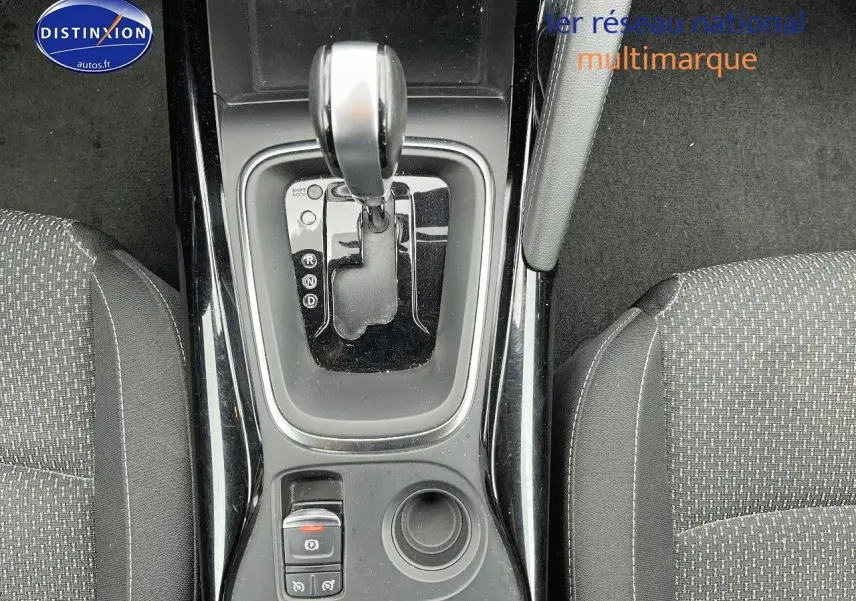 Vue plongeante sur la console centrale noire avec levier de boîte auto et sièges tissu gris du Renault Kadjar 2018.