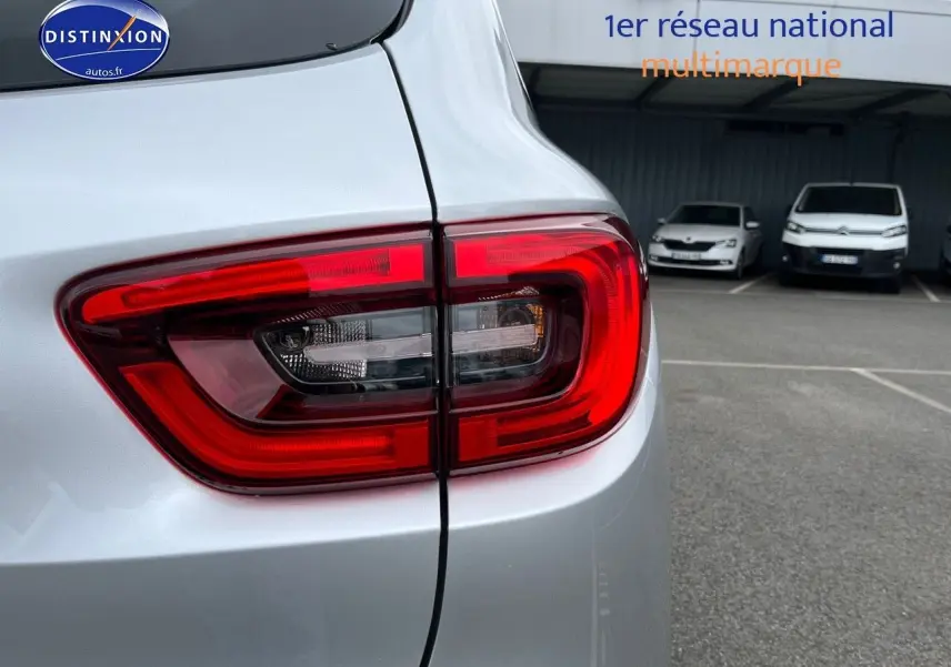 Gros plan sur le feu arrière droit d’un Renault Kadjar gris platine, avec partie de la carrosserie visible.