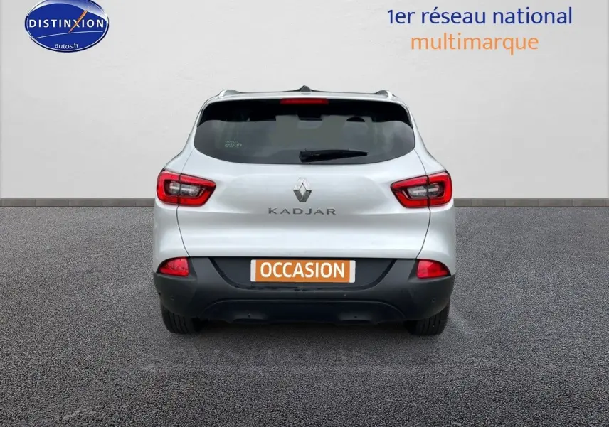Vue arrière d'un Renault Kadjar gris platine avec feux rouges et plaque "OCCASION" sur fond neutre.