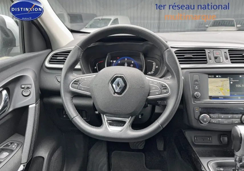 Vue intérieure centrée sur le volant cuir multifonction d’un Renault Kadjar gris Platine de 2018 avec écran tactile et commandes au volant.