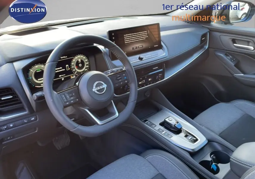 Vue intérieure côté conducteur du Nissan Qashqai 2025 gris argile, montrant le tableau de bord digital et la console centrale moderne.