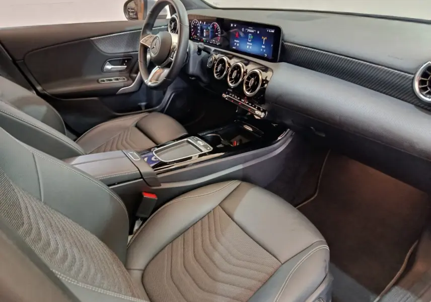 Vue intérieure côté conducteur de la Mercedes Classe A 250 e Business Line 2023, avec tableau de bord numérique et volant cuir alu.