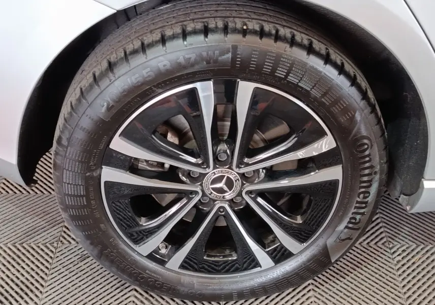 Gros plan sur la roue avant droite gris clair de la Mercedes Classe A 250 e Business Line avec jante alliage noir et argent.