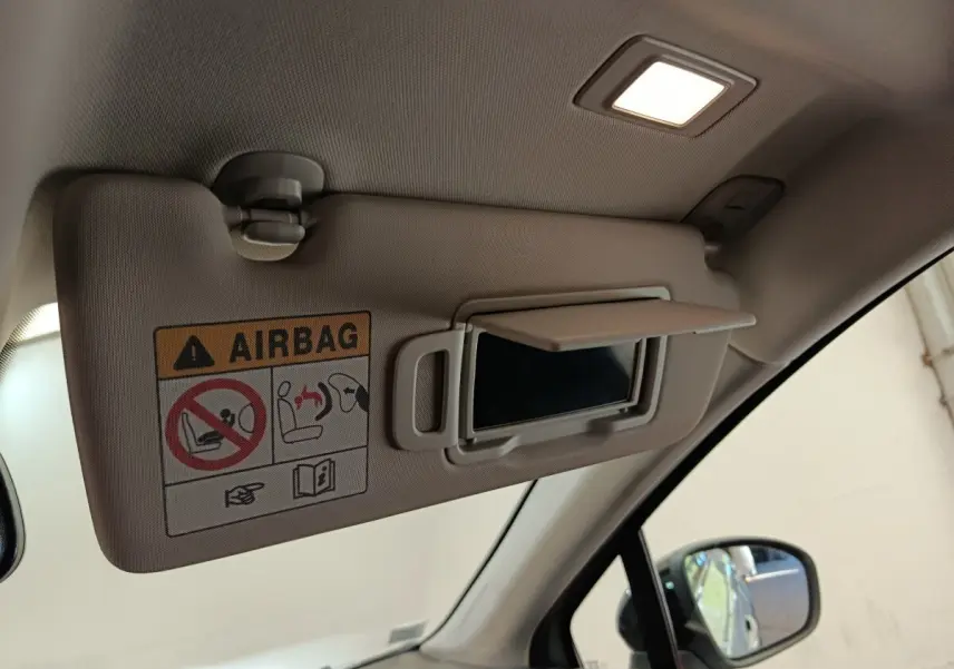 Détail intérieur du pare-soleil côté conducteur avec miroir et avertissement airbag dans un Renault Captur gris clair.
