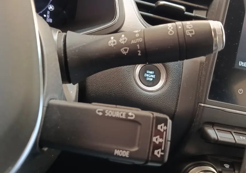 Gros plan intérieur sur le bouton start/stop et les commandes au volant du Renault Captur gris clair Intens E-TECH 2021.
