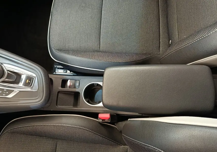 Vue plongeante sur la console centrale et les sièges noirs du Renault Captur Intens E-TECH Plug-in 160 gris clair 2021.