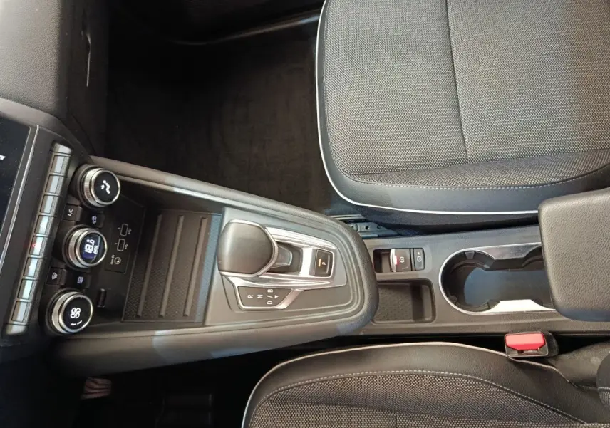 Vue intérieure centrée sur la console centrale et levier de vitesse automatique du Renault Captur gris clair 2021.
