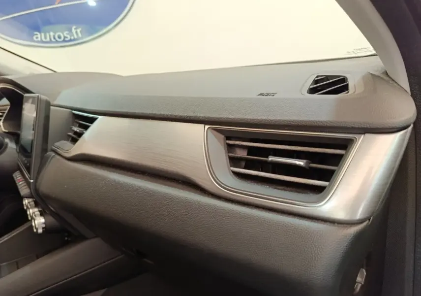 Vue intérieure du tableau de bord côté passager du Renault Captur gris clair, avec aérateur et finition métal brossé.