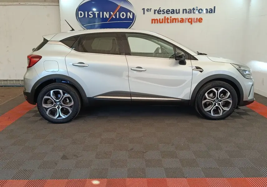 Profil droit d'un Renault Captur Intens E-TECH Plug-in 160 gris clair, avec jantes alliage et détails noirs contrastants.