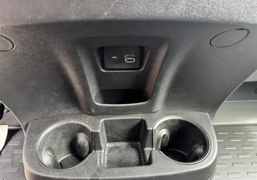 Gros plan sur le porte-gobelets noir avec prise USB intégré dans l’habitacle du Citroën Jumper blanc.