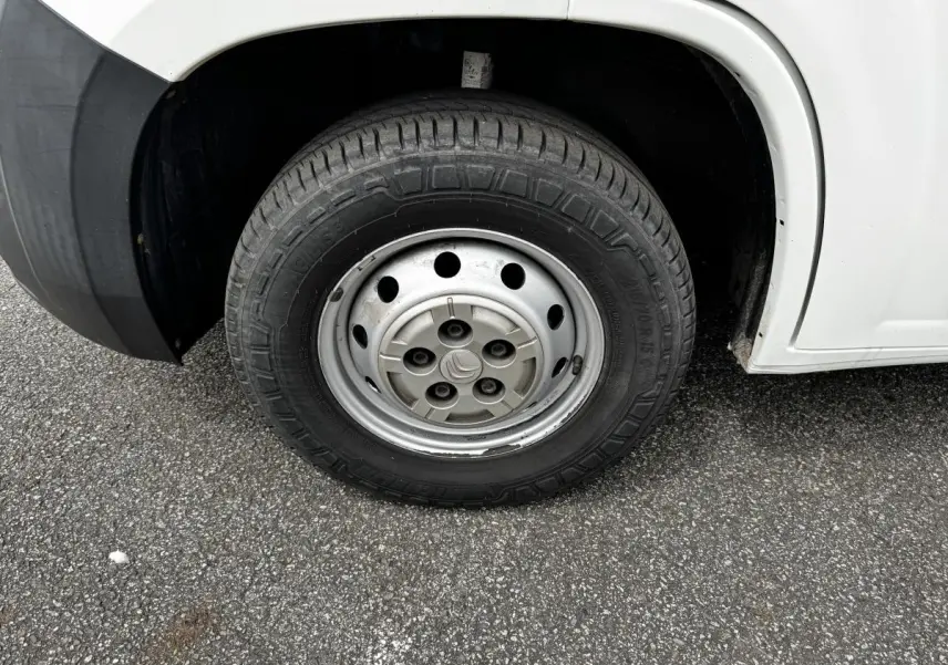 Gros plan sur la roue avant droite acier d’un Citroën Jumper blanc, avec logo Citroën au centre de la jante.
