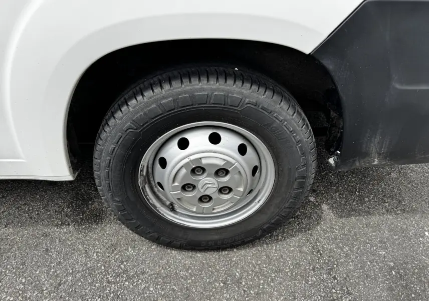 Gros plan sur la roue avant droite en jante acier du Citroën Jumper blanc, avec logo Citroën au centre.