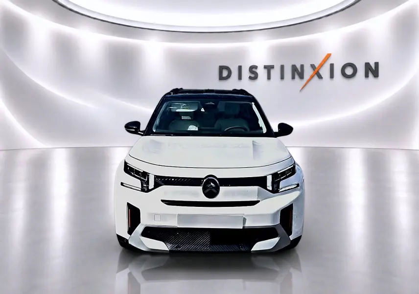 Vue frontale d'un Citroën C3 Aircross blanc avec toit noir, dans un studio lumineux au logo Distinxion en arrière-plan.