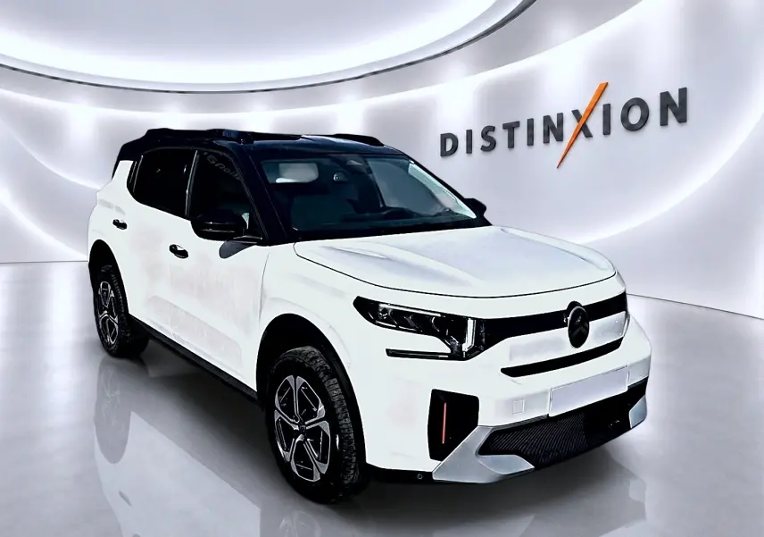 Citroën C3 Aircross blanc en 3/4 avant droit avec toit noir et jantes alu distinctives dans un showroom.