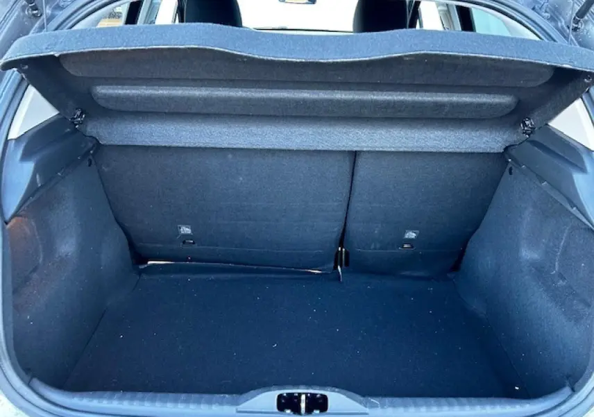 Coffre ouvert vu de l'arrière d'une Citroën C3 gris foncé, montrant l'espace de chargement et la banquette arrière.