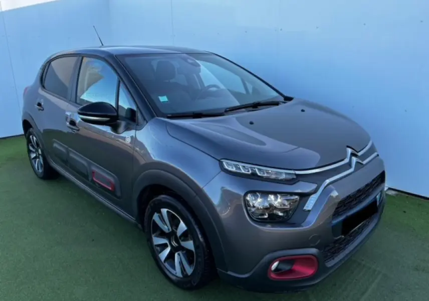 Citroën C3 gris foncé vue 3/4 avant droit avec inserts rouges sur pare-chocs et protections latérales