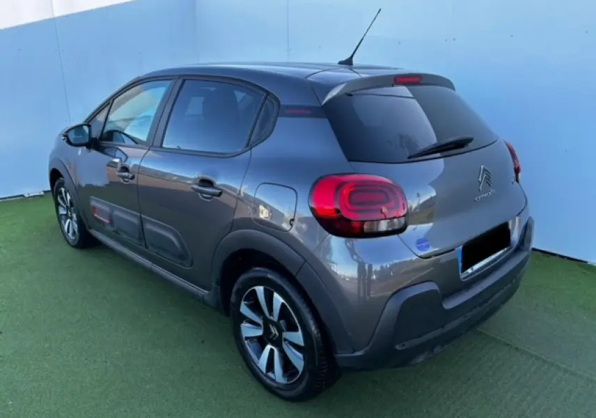 Citroën C3 gris foncé vue 3/4 arrière droit avec jantes alliage et vitres arrière surteintées.