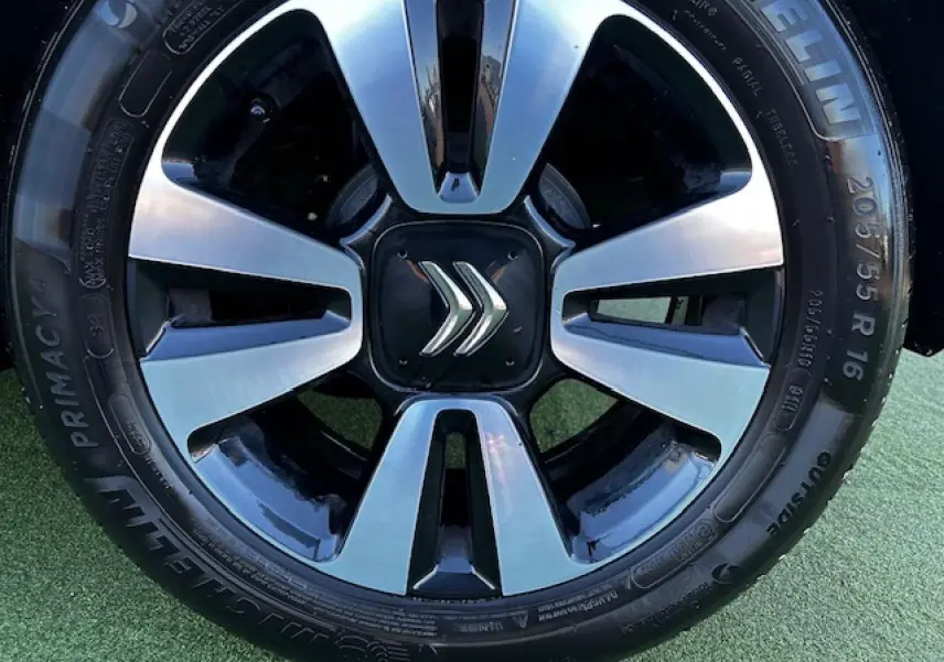 Gros plan sur la jante alliage 16 pouces diamantée noire et argentée avec logo Citroën au centre sur pneu Michelin.