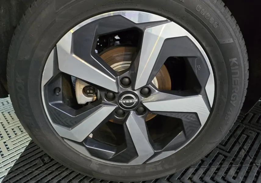 Gros plan sur la jante alliage 18 pouces bicolore du Nissan Qashqai gris silver 2024, avec logo central visible.