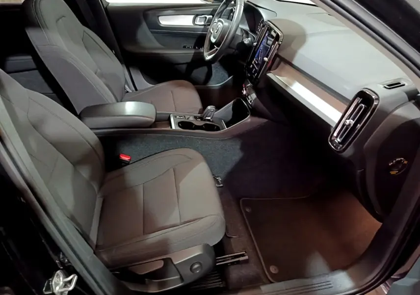 Vue intérieure côté passager du Volvo XC40 Recharge T4 Business 2020, sièges tissu gris et tableau de bord moderne noir et argent.