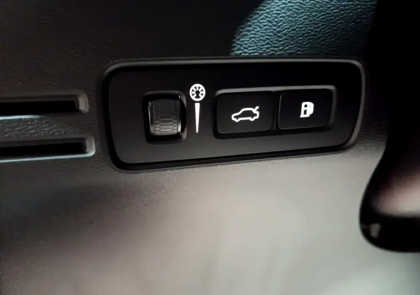 Gros plan sur les commandes d'ouverture du coffre et du réservoir dans l'habitacle noir du Volvo XC40 Recharge T4 Business.