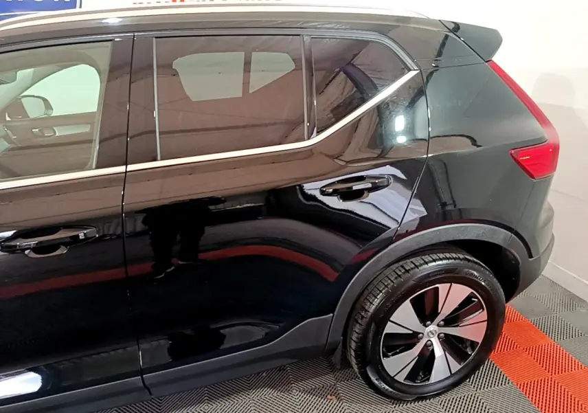 Vue latérale côté droit du Volvo XC40 Recharge T4 Business noir, mettant en valeur la ligne de toit et la roue arrière design.