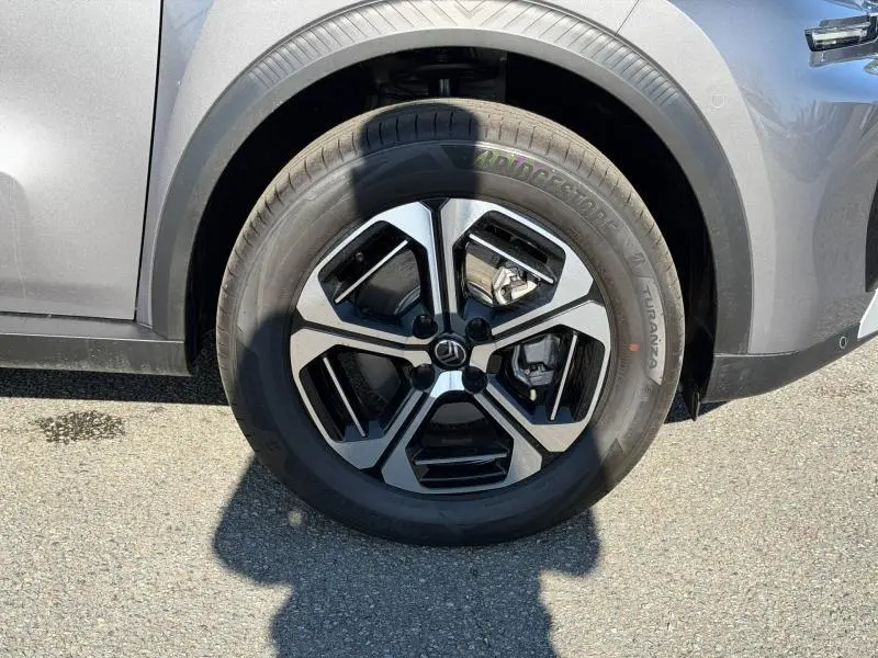 Gros plan sur la roue avant gauche du Citroën C3 Aircross gris Mercury avec jante alu noire et argentée.