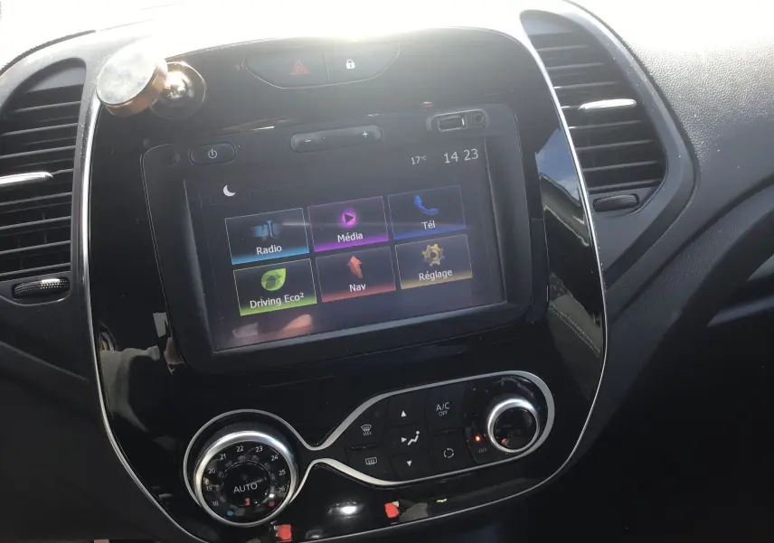 Vue rapprochée de la console centrale du Renault Captur beige/marron avec écran tactile affichant les options multimédia et navigation.