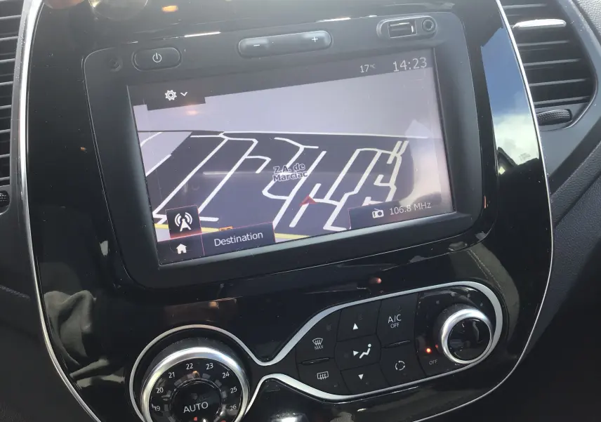 Vue rapprochée de l’écran tactile central du Renault Captur beige/marron 2018 avec navigation et commandes de climatisation.