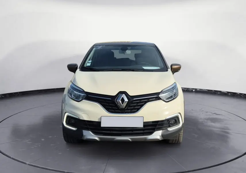 Vue frontale d'un Renault Captur beige et marron, mettant en valeur la calandre noire et les feux LED en forme de C.