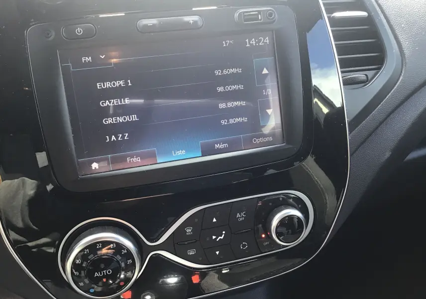 Vue rapprochée de la console centrale du Renault Captur 2018, affichant l’écran multimédia et les commandes de climatisation.