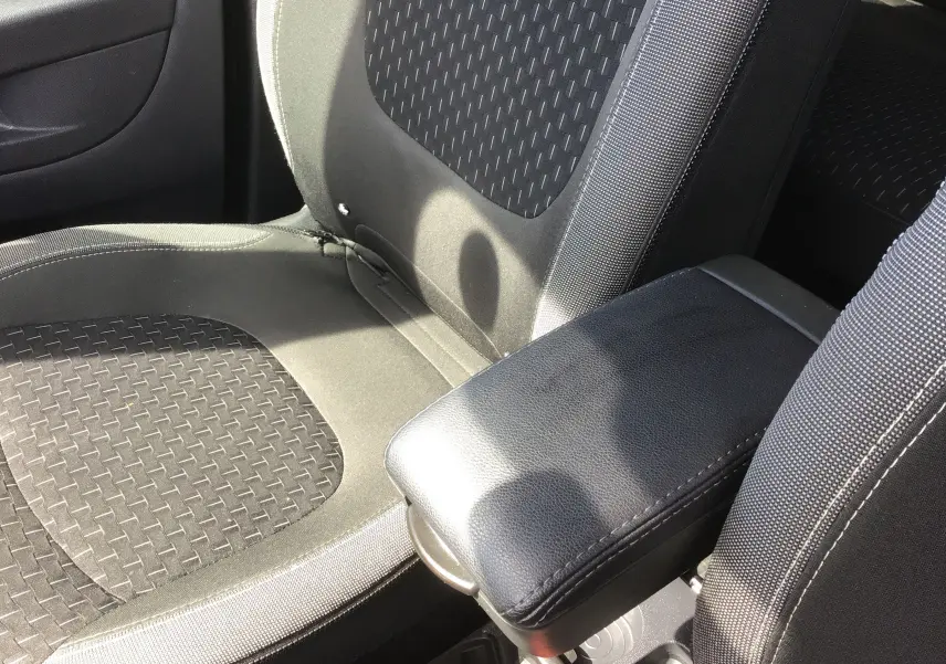 Gros plan sur les sièges avant noirs et gris du Renault Captur 2018 avec accoudoir central en cuir noir.